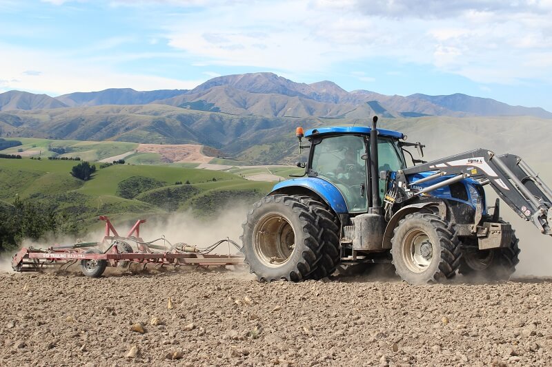 Rata 812 Trailing Maxitill cultivating stony ground behind New Holland Tractor