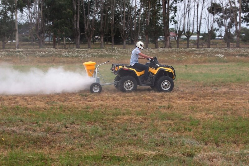 Vogal Mag 45 spreading Causmag magnesium behind motorbike - Vogal Spreaders