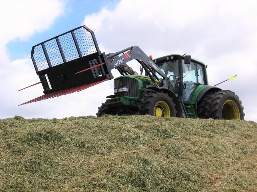 John Deere tractor making a silage stack